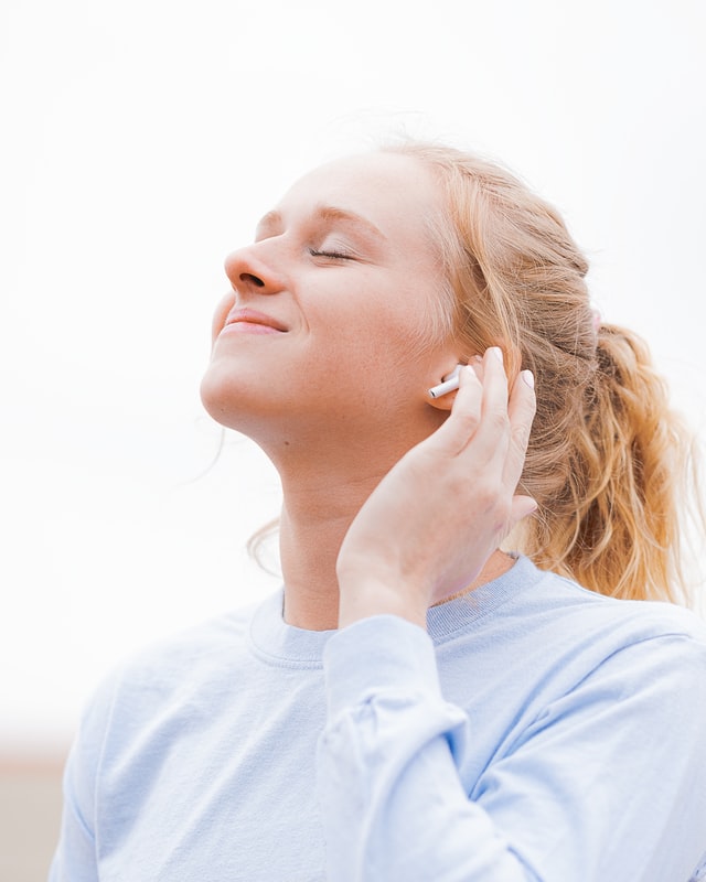 Woman happy listening to music with earphones and smiling